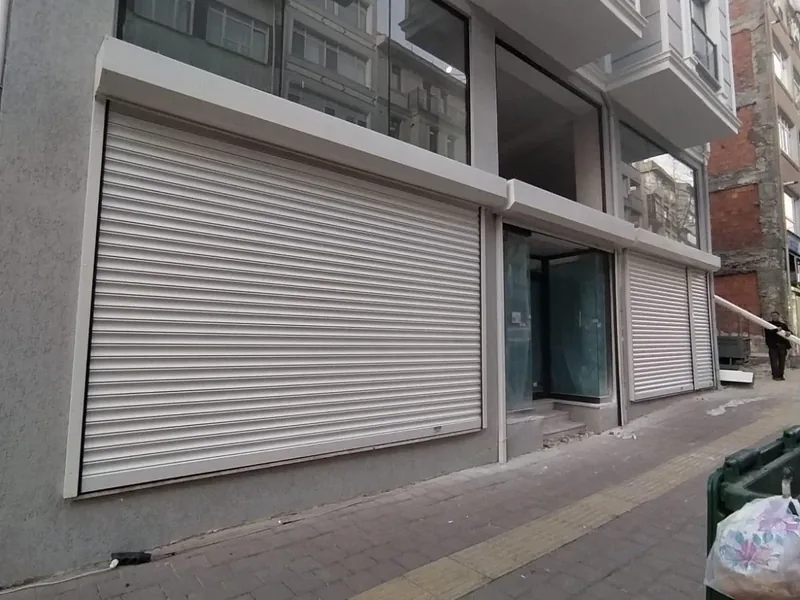 Apartman altındaki iki dükkân cephesinde beyaz kepenkler